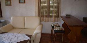 a living room with a white couch and a wooden table at Apartment in Veli Losinj 36509 in Veli Lošinj