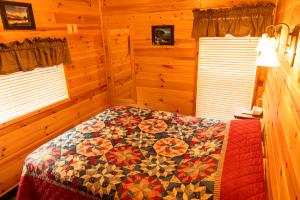 a bedroom with a bed with a quilt on it at Crescent Beach and RV Park in Port Angeles
