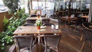 restauracja z drewnianymi stołami, krzesłami i roślinami w obiekcie Payidar HOTEL w Stambule