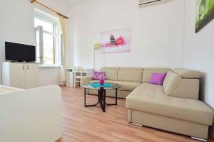 ein Wohnzimmer mit einem Sofa und einem Tisch in der Unterkunft Apartment in Rabac 16989 in Rabac