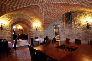 una sala da pranzo con tavolo, sedie e muro di mattoni di Apartment in Capolona/Toskana 23622 a Capolona