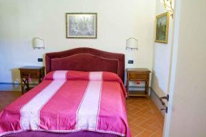 una camera con un letto con una coperta rosa e bianca di Apartment in Capolona/Toskana 23622 a Capolona