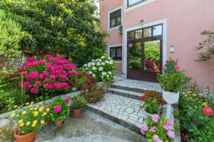 a bunch of flowers in pots in front of a building at Apartment in Crikvenica 14098 in Dramalj