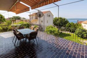 a patio with a table and chairs on a balcony at Apartment in Crikvenica 14098 in Dramalj