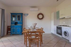 a kitchen with a table and a blue cabinet at Holiday home in Baja Sardinia 30355 in Baja Sardinia