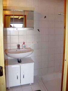 a white bathroom with a sink and a tub at Holiday house in Supetarska Draga - Insel Rab 36083 in Supetarska Draga