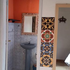 een badkamer met een wastafel en een spiegel bij Pousada Esquina de Lavras in Lavras Novas