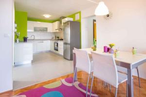 a kitchen with a table and chairs and a refrigerator at Apartments in Vrbnik/Insel Krk 36002 in Vrbnik