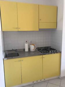 a kitchen with yellow cabinets and a sink at Apartments in Hvar/Insel Hvar 33535 in Hvar