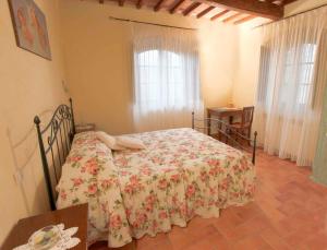 a bedroom with a bed with a floral bedspread at Holiday home in Montalcino/Toskana 24097 in Montalcino