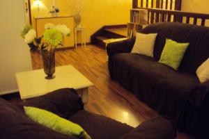 a living room with two couches and a vase with flowers at Logis Hôtel Les 3B in Nouilhan