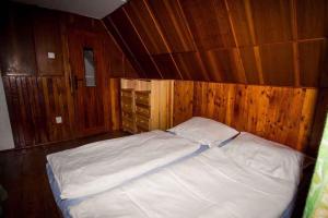 a bed in a room with wooden walls at Holiday home Podbanske - Hohe Tatra 26186 in Pribylina