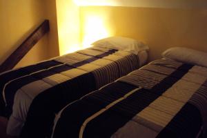 two beds sitting next to each other in a room at Logis Hôtel Les 3B in Nouilhan
