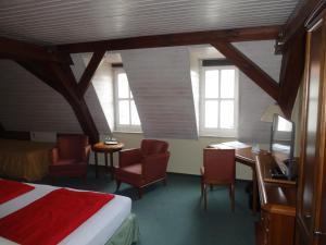 a bedroom with a bed and a desk and chairs at Lausitzhof in Lübbenau