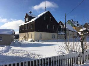 a large black and white building in the snow at Apartment in Deutscheinsiedel 36165 in Deutscheinsiedel