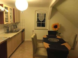 a kitchen with a table and a window with a sunflower at Apartment in Deutscheinsiedel 36165 in Deutscheinsiedel