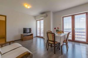 a bedroom with a table and chairs and a television at Apartments in Crikvenica 14113 in Crikvenica