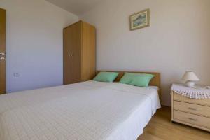 a bedroom with a bed and a cabinet and a nightstand at Apartments in Crikvenica 14113 in Crikvenica