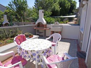 a patio with a table and chairs and a stove at Studio in Veli Losinj 14957 in Veli Lošinj