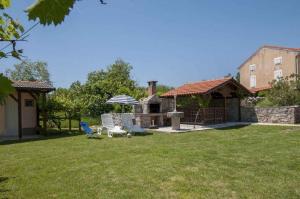 a yard with a grill and an umbrella at Apartment in Risika - Island Krk 35824 in Risika +11 photos