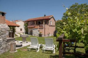 a group of chairs sitting in the yard of a house at Apartment in Risika - Island Krk 35824 in Risika