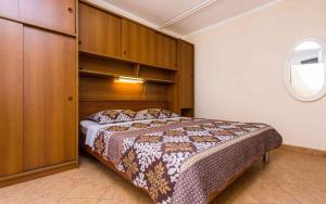 a bedroom with a bed with a wooden headboard at Apartment in Vrbnik/Insel Krk 35843 in Vrbnik