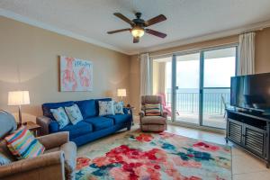 een woonkamer met een blauwe bank en een flatscreen-tv bij Twin Palms Resort #601 by Book That Condo in Panama City Beach