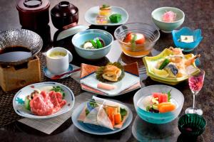 una mesa cubierta con platos de comida y tazones de comida en Shorenji Lake Hotel, en Nabari