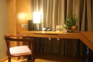 a desk with a lamp and a chair in a room at HUALUXE Yangjiang City Center, an IHG Hotel in Yangjiang