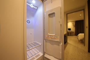 a small refrigerator in a room with a bedroom at Zam101 Hotel Gimhae in Gimhae