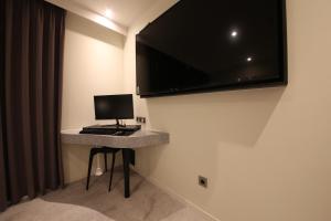 Pokój z biurkiem z monitorem komputerowym na ścianie w obiekcie Zam101 Hotel Gimhae w mieście Gimhae