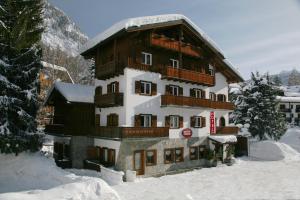 a large building with snow on the ground at B&B Residence Checrouit in Courmayeur