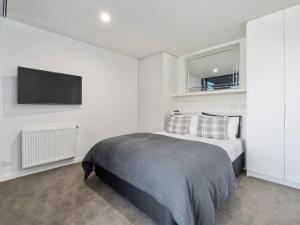 a bedroom with a bed and a flat screen tv at The Bunker Alpha B in Queenstown