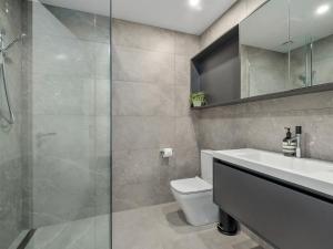 a bathroom with a toilet and a sink and a shower at The Bunker Alpha B in Queenstown