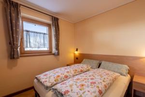 1 dormitorio con cama y ventana en Baita Nicoló en Livigno