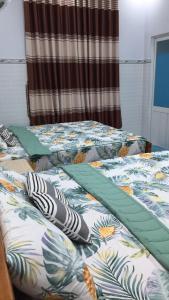 - 2 lits jumeaux dans une chambre avec une couette dans l'établissement HÒANG HÔN HOMESTAY, à Ben Tre