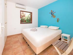a bedroom with a white bed and a blue wall at Pool Villa near Jan Thiel in Jan Thiel +26 photos