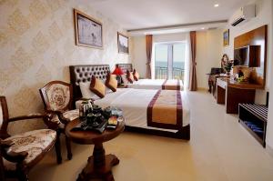 Una habitación de hotel con una cama, una mesa y sillas. en Boss Hotel, en Nha Trang