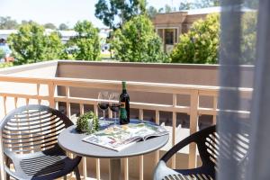 a table with two chairs and a bottle of wine at Quest Echuca in Echuca