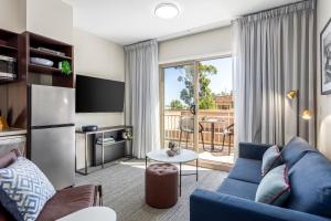 a living room filled with furniture and a tv at Quest Echuca in Echuca
