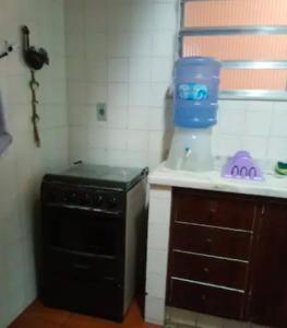a small kitchen with a black stove and a sink at Casa em Itaipava Piscina Lareira e Pet Friendly in Petrópolis