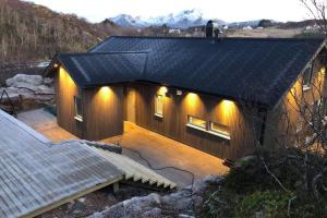 Una casa con luces en el costado. en Vikran Seaside Lodge, en Straumsjøen