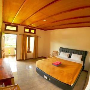a bedroom with a large bed with a wooden ceiling at PIAS POPPIES HOTEL in Rantepao