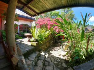 un giardino con fiori rosa e un sentiero in pietra di PIAS POPPIES HOTEL a Rantepao