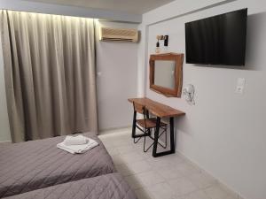 a bedroom with a bed and a desk and a television at Jannos Beach hotel in Laganas