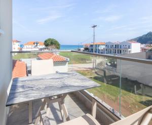 a table on a balcony with a view of the ocean at MEDITERRANEO in Skala Potamias