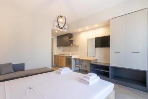 a bedroom with a white bed and a kitchen at MEDITERRANEO in Skala Potamias +16 photos