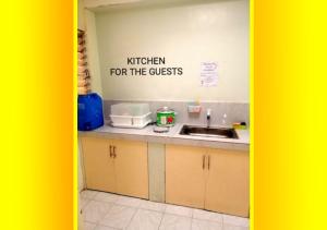 a kitchen with a kitchen for the guests sign on the wall at Megaworld Area Place with Fan 2 and WIFI in Iloilo City