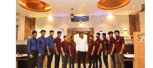 um grupo de homens posando para uma foto em um restaurante em SSK MALLIGAI RESIDENCY em Ramanathapuram