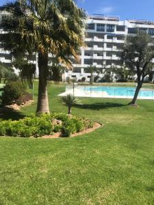 a resort with a pool and palm trees and a building at Jardines Puerto Banus Rooms in Marbella